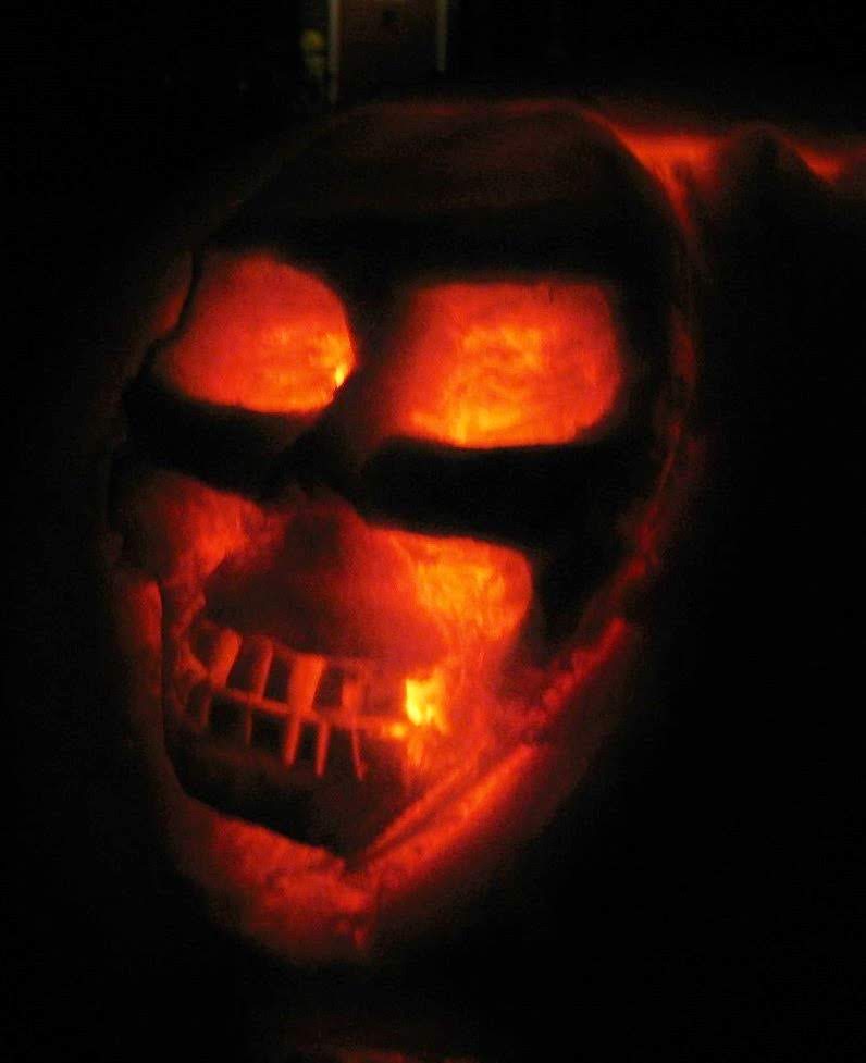 Pumpkin carving from 2001 &mdash; The Skull. Interior wall sculpted to varying thickness so the candle lights the orbits bright and dims along the jaw.